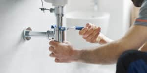 Skilled technicians performing plumbing services in home